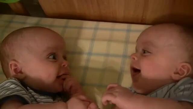 Сладки бебета близнаци се гледат и смеят