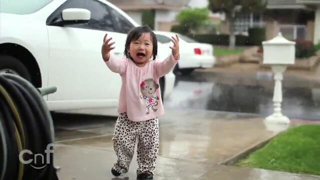 Малко момиченце се наслаждава на първия дъжд