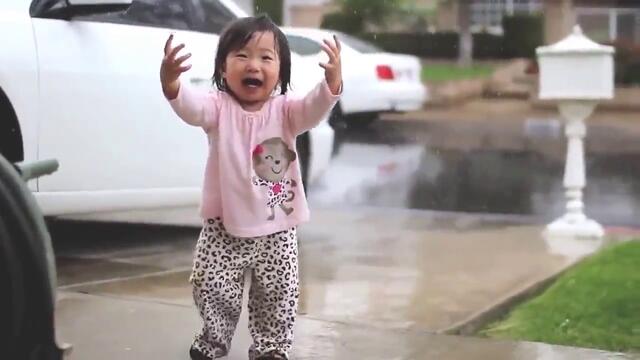 Малко момиченце се среща с дъжда за първи път